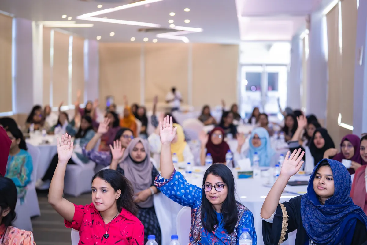Shoktikonna participants raising their hands during a workshop session