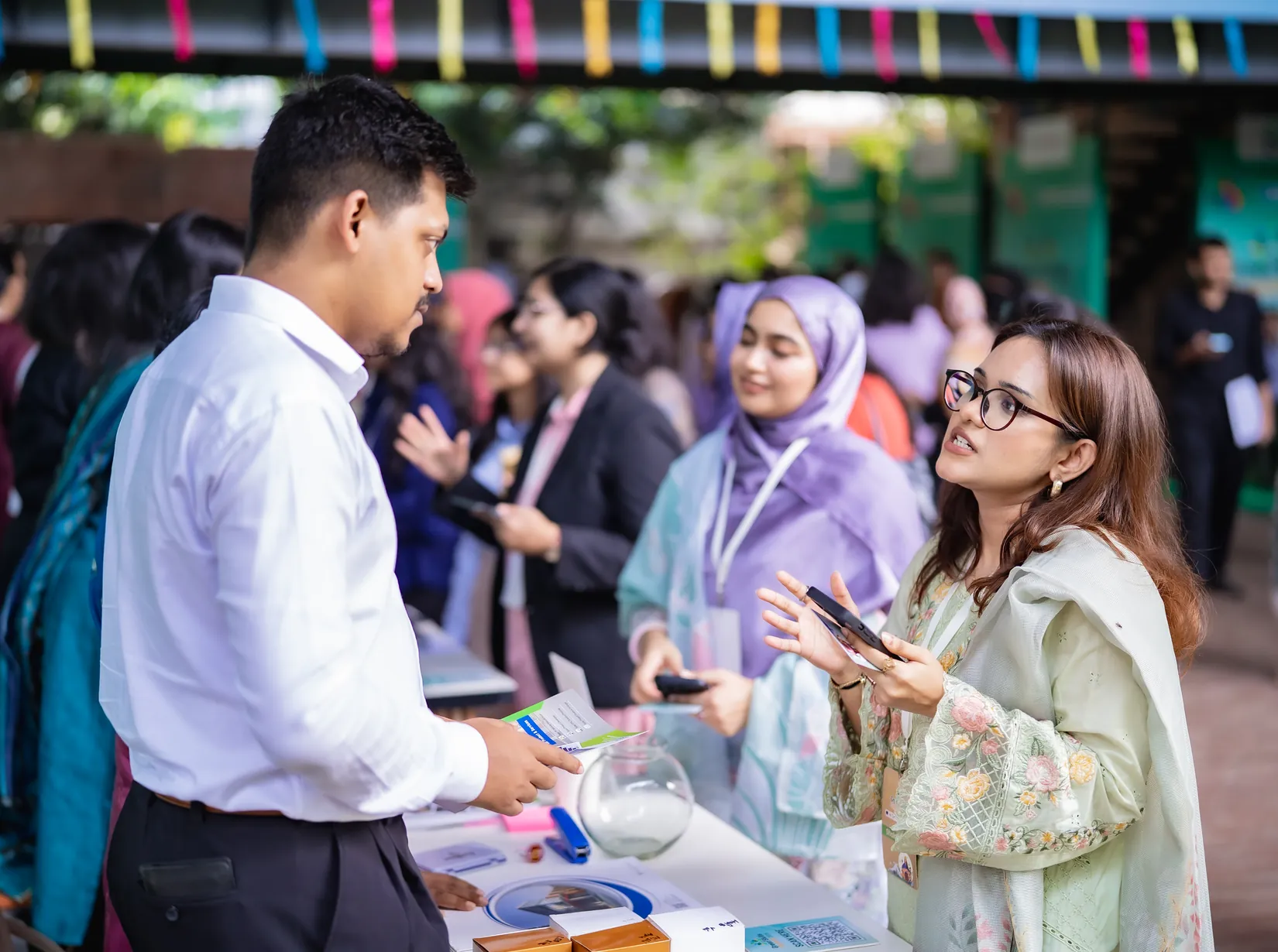 A participant talking with a company representative at an employer booth at the Green Skills Summit